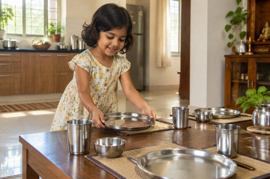Young Indian girl setting steel plates and tumblers on a dining table as a household chore