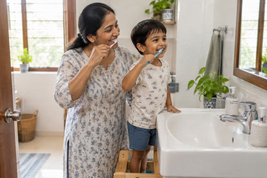Indian mother and young son brushing their teeth together at the bathroom sink in the morning